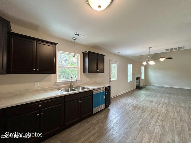 kitchen featuring a notable chandelier, plenty of natural light, dishwasher, sink, and light hardwood / wood-style flooring