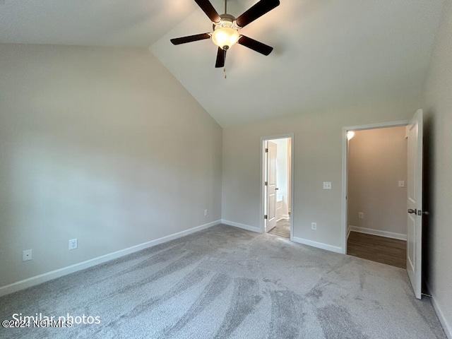 unfurnished bedroom featuring ceiling fan, ensuite bath, light carpet, and high vaulted ceiling