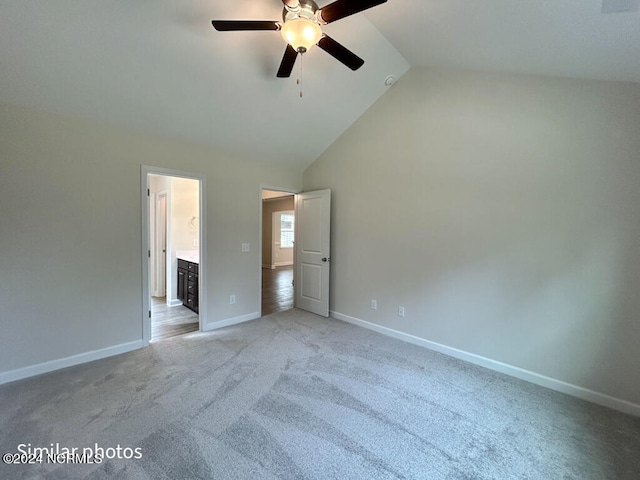 unfurnished bedroom with light carpet, ceiling fan, ensuite bath, and high vaulted ceiling