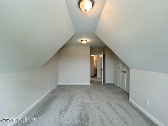 additional living space with vaulted ceiling and light colored carpet