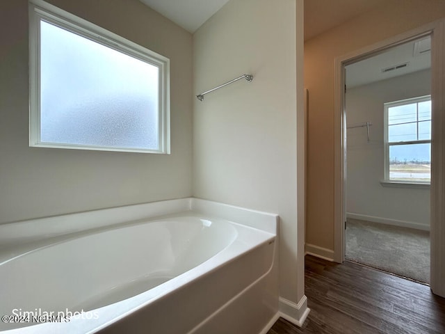 bathroom with a tub and hardwood / wood-style floors