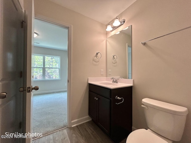 bathroom featuring toilet, large vanity, and hardwood / wood-style flooring