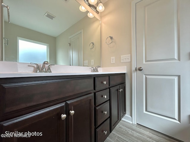 bathroom with hardwood / wood-style floors and dual bowl vanity