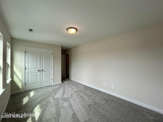 unfurnished bedroom featuring a closet and light carpet