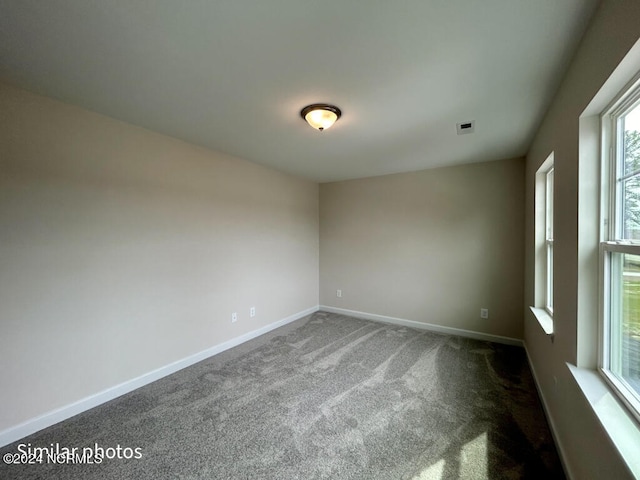 empty room featuring dark colored carpet