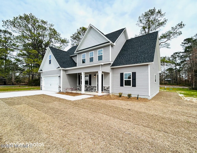 view of front of home with covered porch, a front lawn, and a garage