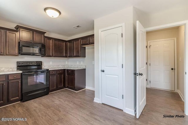 kitchen with wood-type flooring, black appliances, and dark brown cabinetry