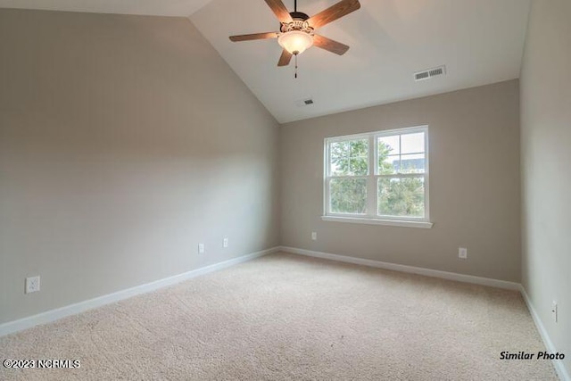 spare room featuring vaulted ceiling, light colored carpet, and ceiling fan