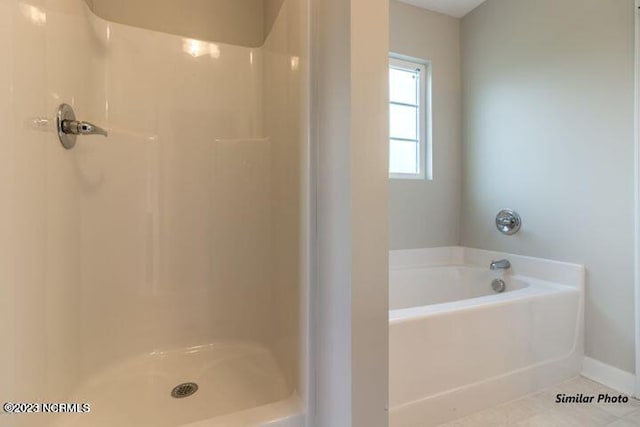 bathroom with tile flooring and separate shower and tub