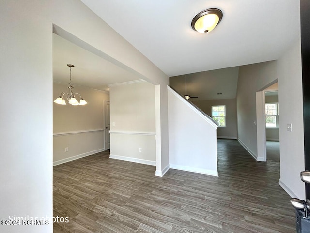 unfurnished room with ceiling fan with notable chandelier and dark hardwood / wood-style floors