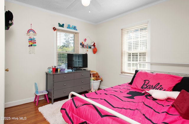 bedroom with crown molding, a ceiling fan, baseboards, and wood finished floors