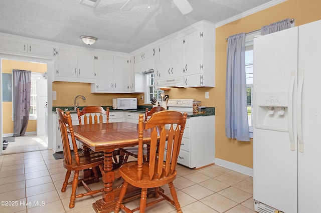 dining space featuring a textured ceiling, plenty of natural light, and light tile patterned floors