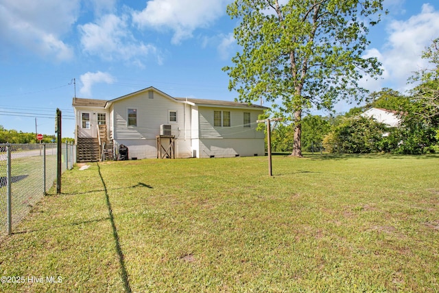 exterior space with fence, a yard, and crawl space