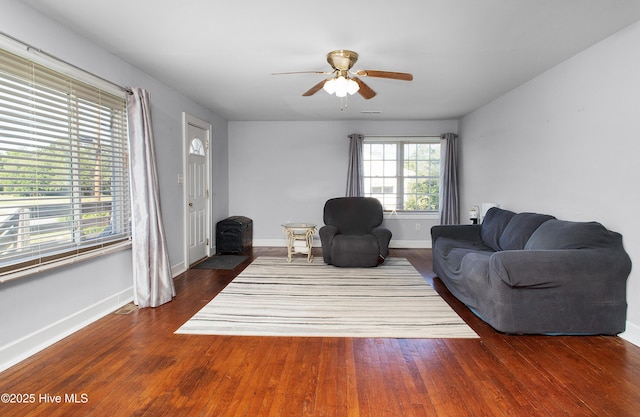 living room with baseboards, ceiling fan, and wood finished floors