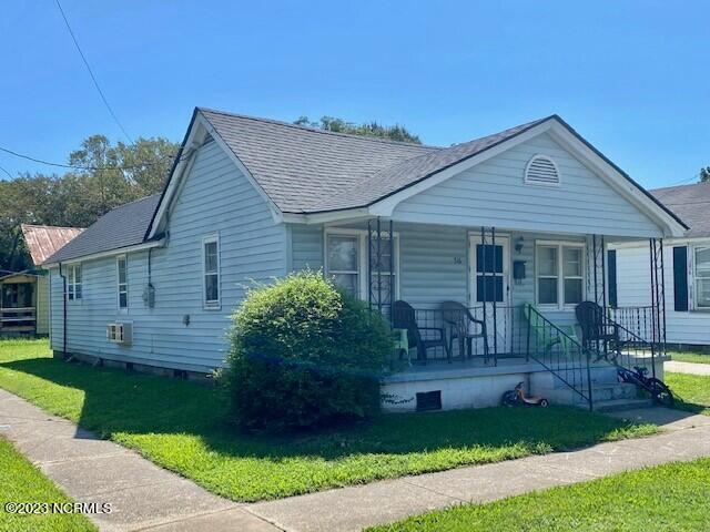 bungalow-style house with covered porch and a front lawn