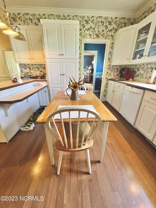 kitchen featuring white dishwasher, hanging light fixtures, white cabinets, and light hardwood / wood-style flooring