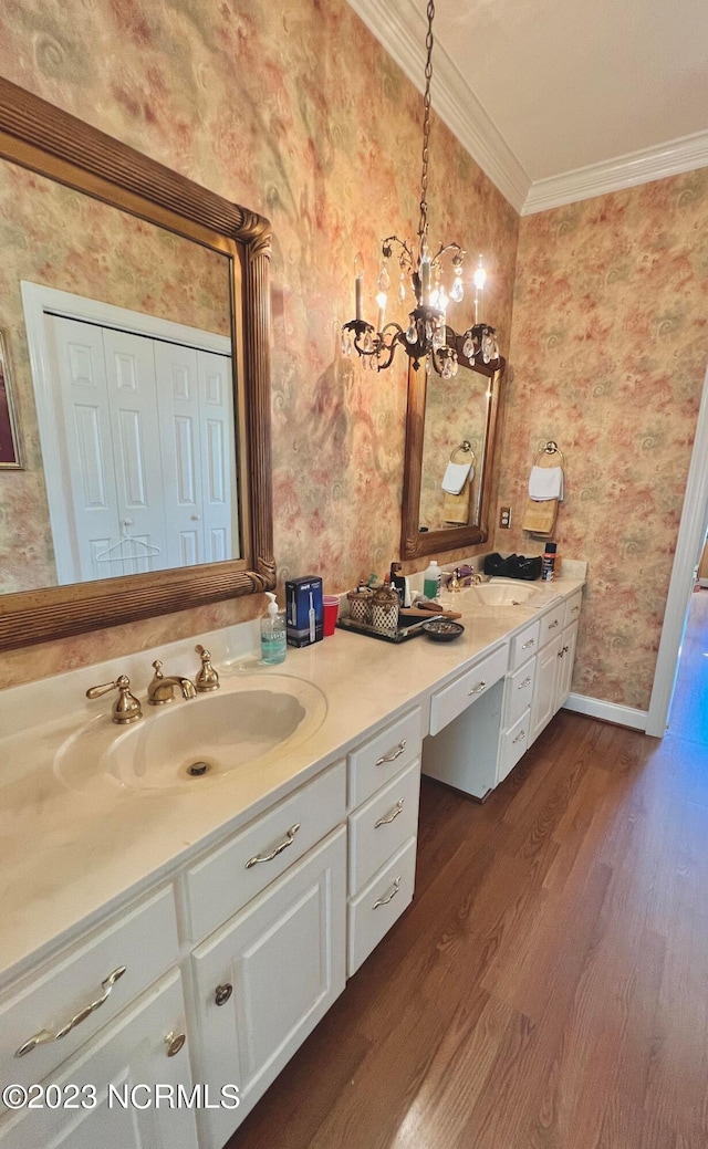 bathroom featuring a chandelier, large vanity, ornamental molding, and wood-type flooring