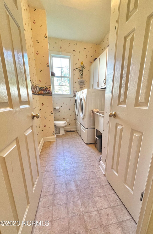 laundry room with washing machine and clothes dryer and light tile floors