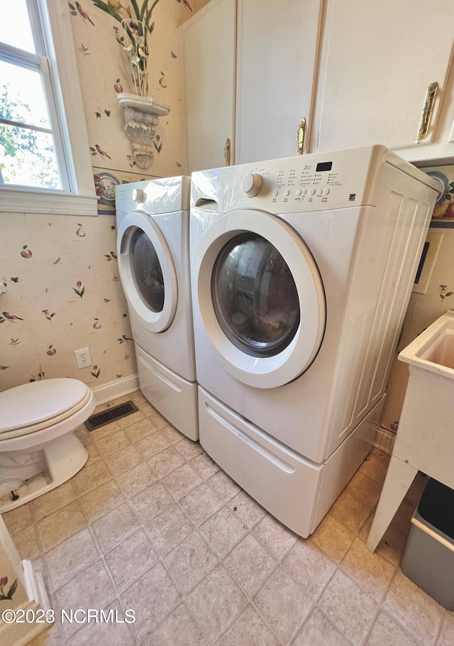 laundry room featuring washer and dryer and light tile floors