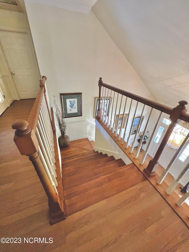 staircase with high vaulted ceiling and dark hardwood / wood-style floors