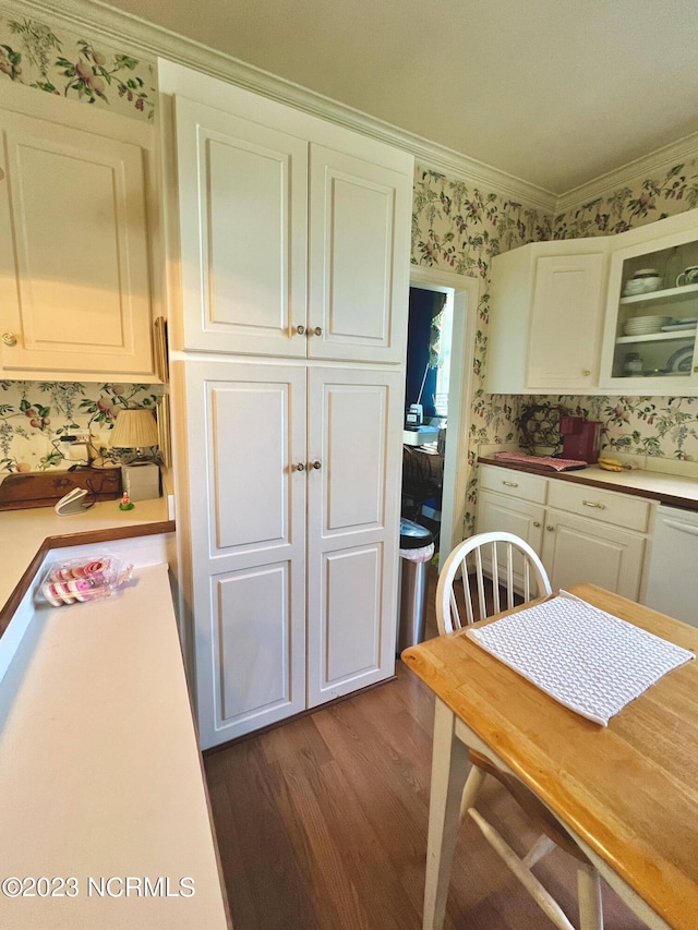 kitchen with white cabinetry, crown molding, white dishwasher, and dark hardwood / wood-style flooring