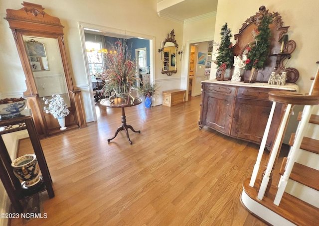 corridor featuring ornamental molding, a chandelier, and light hardwood / wood-style flooring