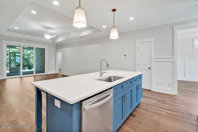 kitchen with dishwasher, a kitchen island with sink, a tray ceiling, and sink