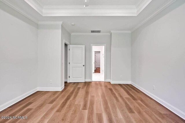 unfurnished bedroom with crown molding and light wood-type flooring