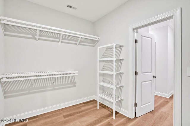 walk in closet with light wood-type flooring