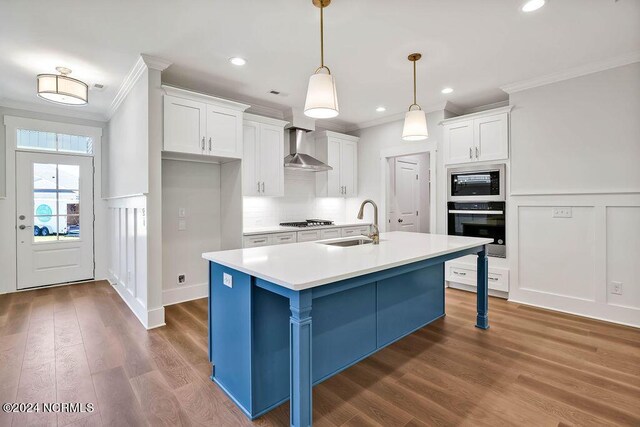 kitchen with a kitchen island with sink, white cabinetry, black appliances, dark hardwood / wood-style flooring, and wall chimney range hood