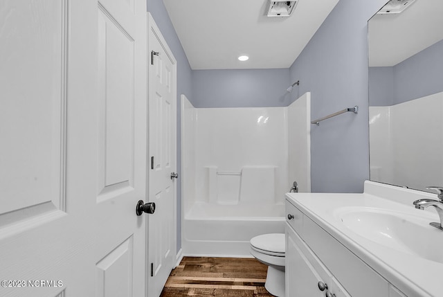 full bathroom with shower / bathing tub combination, toilet, vanity, and hardwood / wood-style flooring