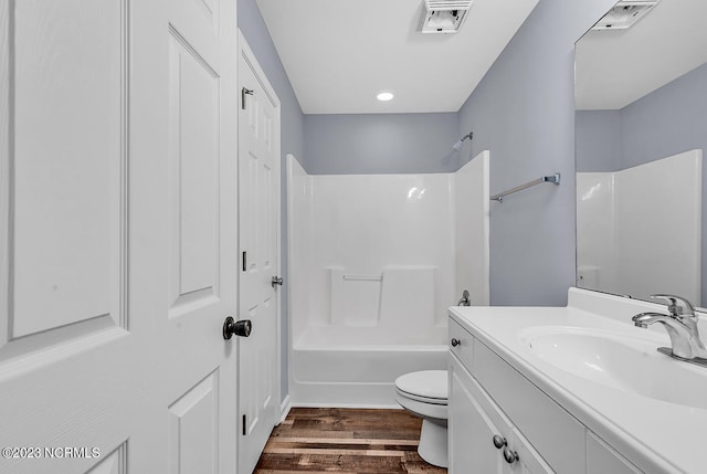 full bathroom featuring toilet, vanity, hardwood / wood-style flooring, and shower / tub combination