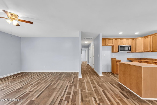 kitchen featuring ceiling fan and dark wood-type flooring