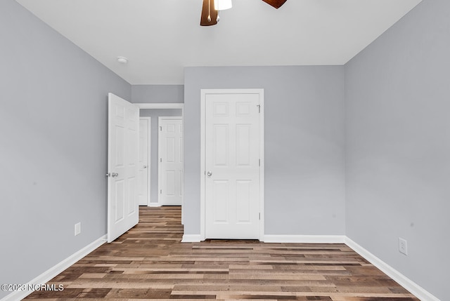 unfurnished bedroom with dark hardwood / wood-style floors and ceiling fan