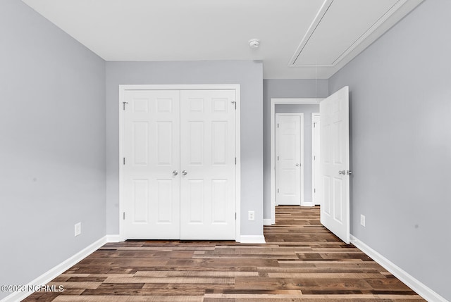 unfurnished bedroom with a closet and dark hardwood / wood-style floors