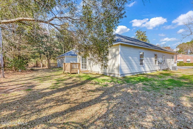 exterior space featuring a deck, central AC unit, and a yard