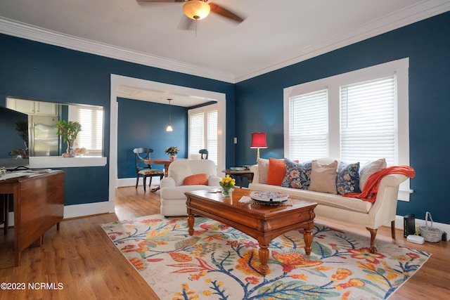 living room with baseboards, ornamental molding, and wood finished floors