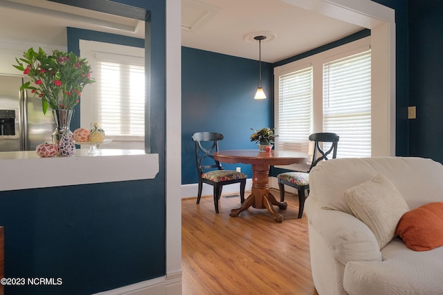 dining space featuring attic access and wood finished floors