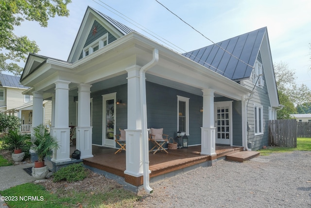 view of side of home featuring covered porch, metal roof, and a standing seam roof