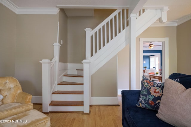 stairs featuring ornamental molding, wood finished floors, and baseboards