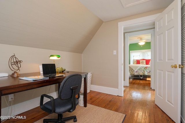 office with light wood-style floors, baseboards, and vaulted ceiling