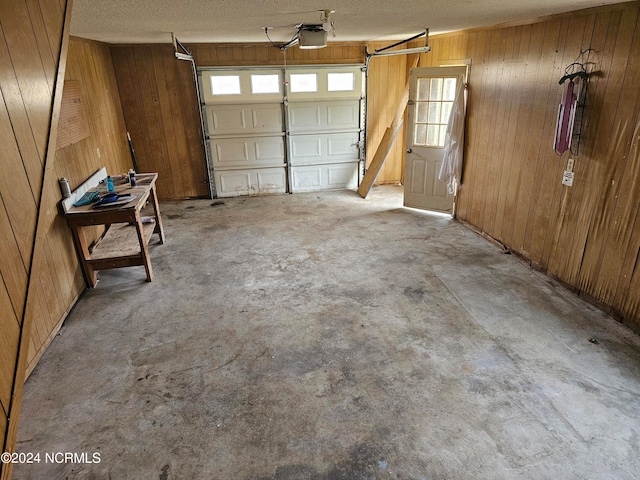 garage with wood walls and a garage door opener