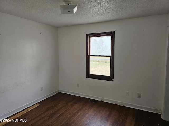 unfurnished room featuring a textured ceiling and dark wood-type flooring