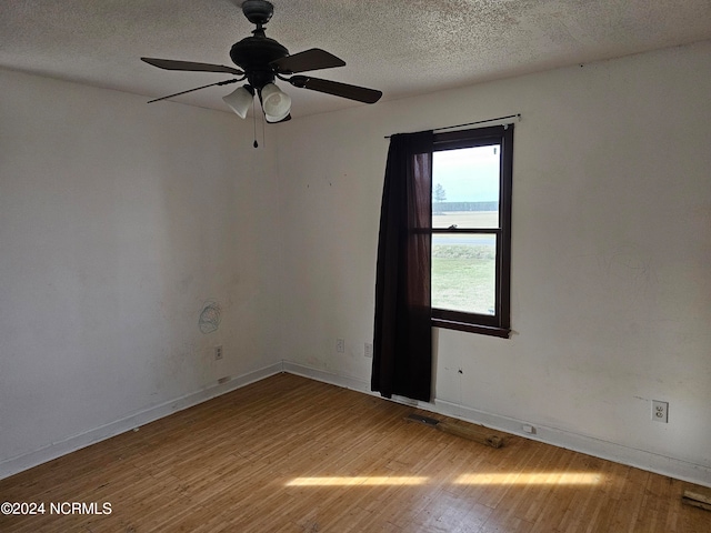 empty room featuring ceiling fan, a textured ceiling, and hardwood / wood-style flooring