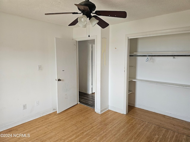 unfurnished bedroom with ceiling fan, a closet, light hardwood / wood-style flooring, and a textured ceiling