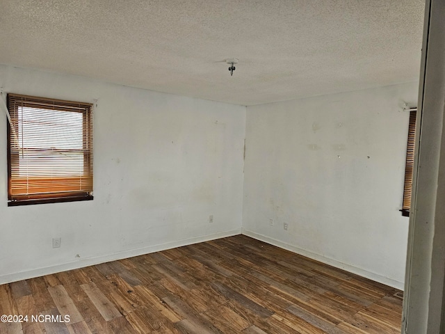 spare room with dark wood-type flooring and a textured ceiling