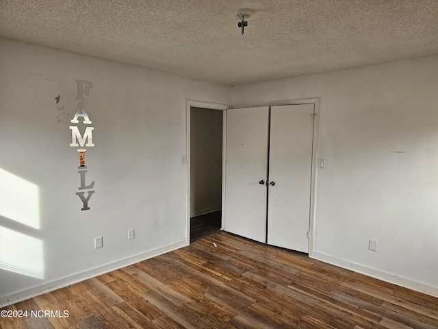 unfurnished bedroom with dark hardwood / wood-style floors and a textured ceiling