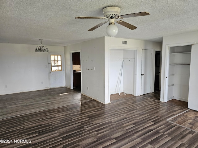 interior space featuring ceiling fan, two closets, dark hardwood / wood-style floors, and a textured ceiling