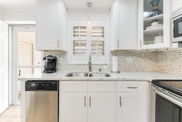 404 Mercer St, Oak Island, NC 28465 - kitchen with appliances with stainless steel finishes, white cabinets, glass insert cabinets, decorative backsplash, and ornamental molding