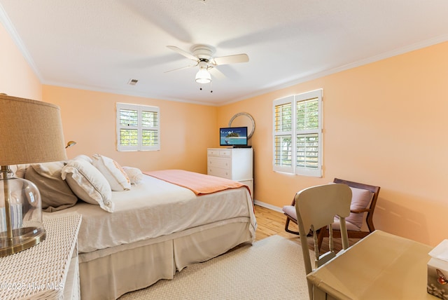 404 Mercer St, Oak Island, NC 28465 - bedroom featuring multiple windows, crown molding, light wood-style floors, and a ceiling fan